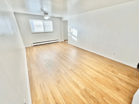 A room with wooden flooring and a window.